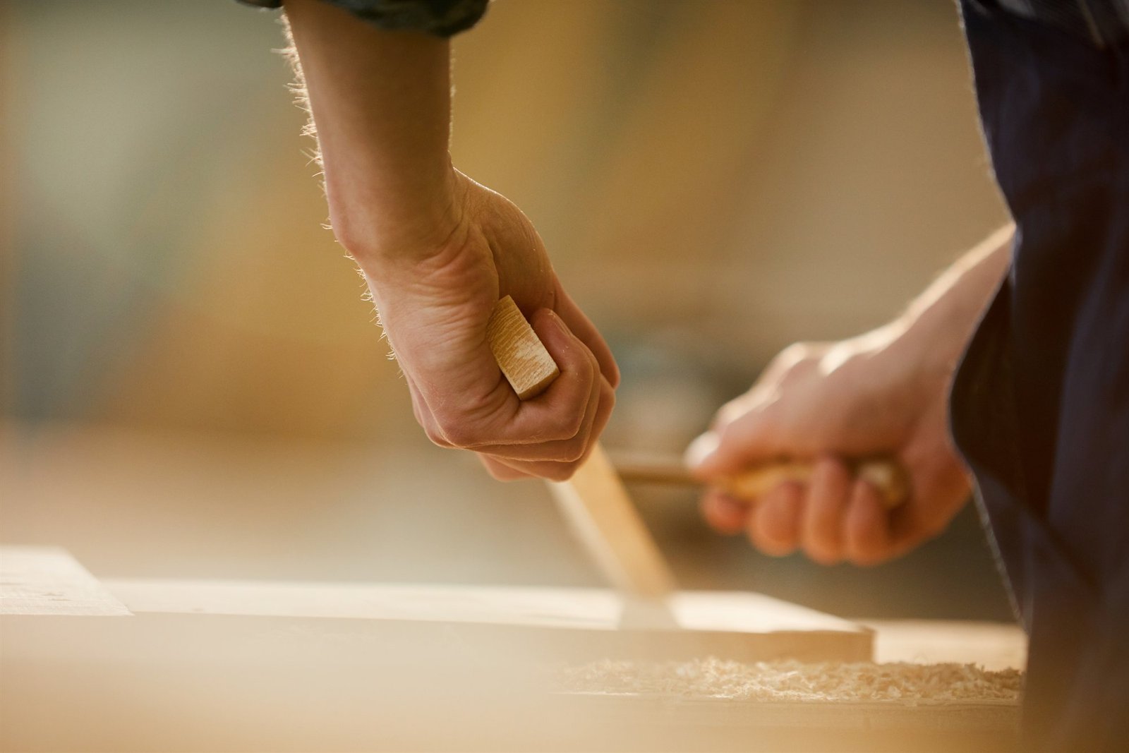 Master carpenter hands crafting custom solid wood joinery in workshop